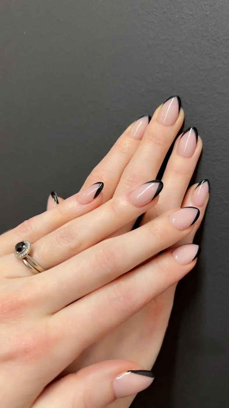 Fine black French tips on nude almond nails, a second angle