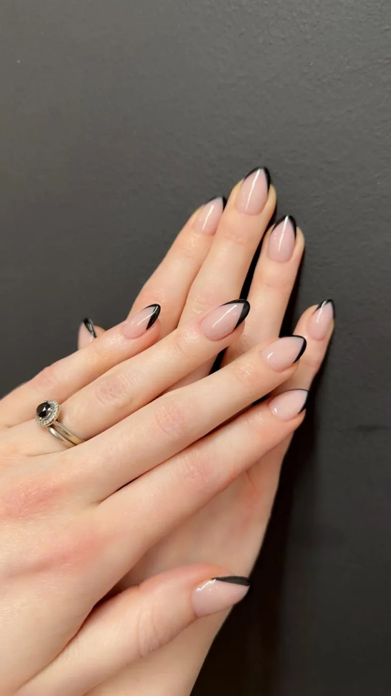 Nude almond nails with fine black French tips