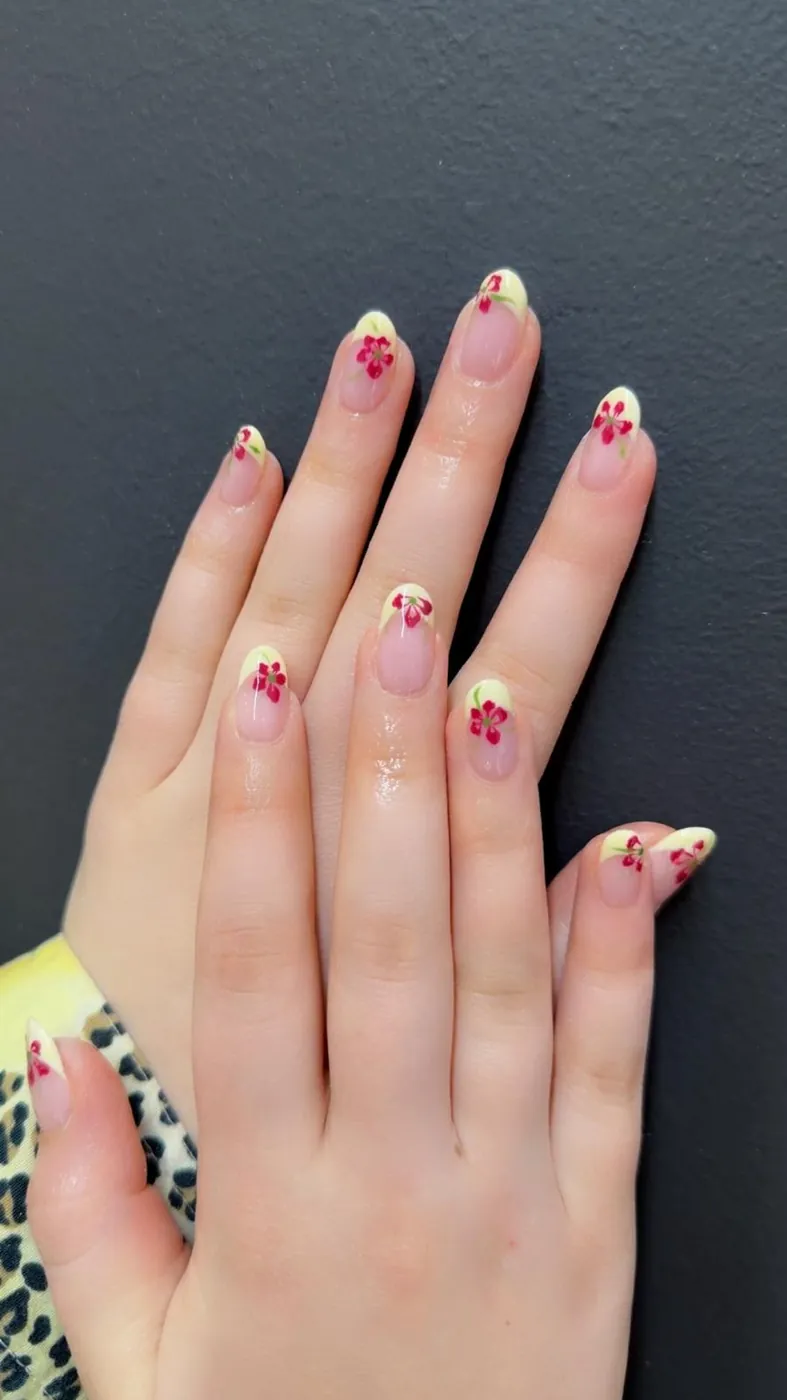 Yellow French tips with red flower nail art, a second angle