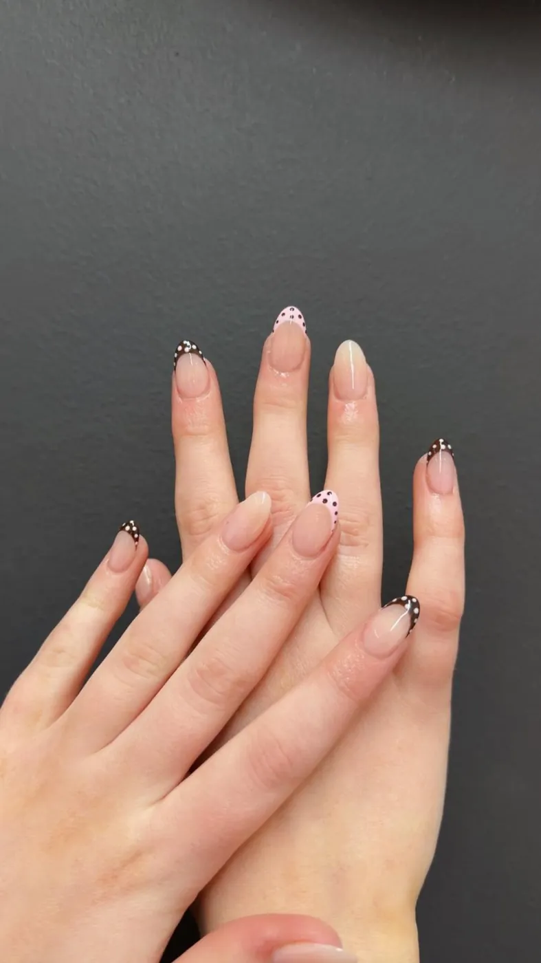 Polka-dot French tips on nude almond nails, a second angle